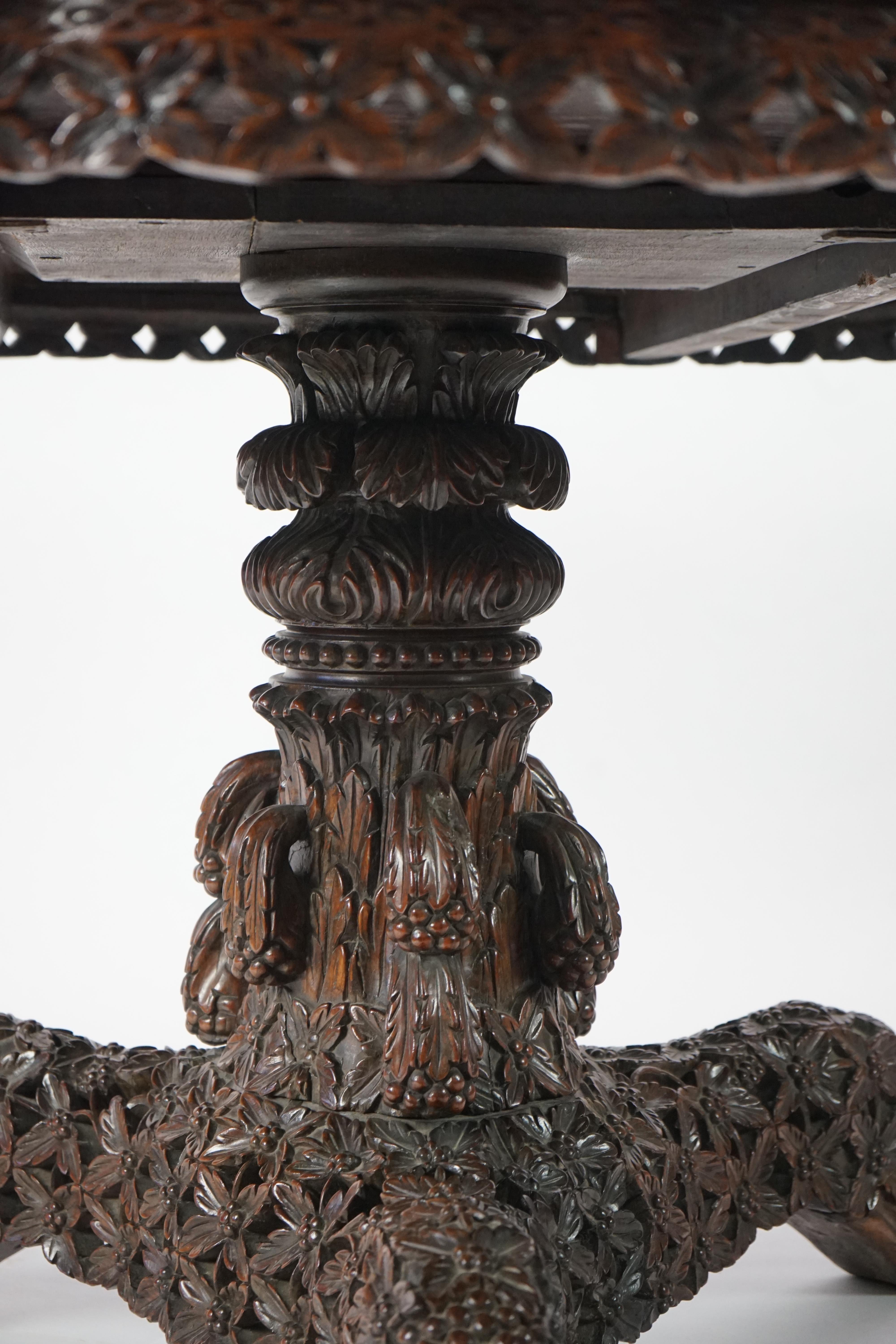 A 19th century Anglo-Indian hardwood foliate carved tilt top centre table